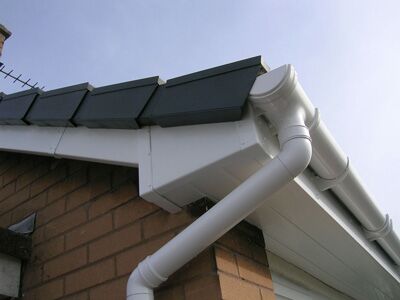 White PVCu guttering and downpipe against brickwork