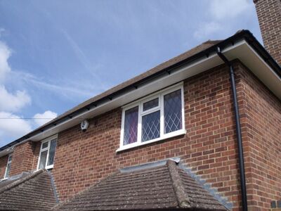 Brick house with dark guttering and leaded windows