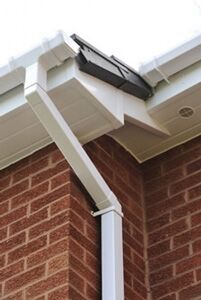 White downpipe and guttering on a brick wall