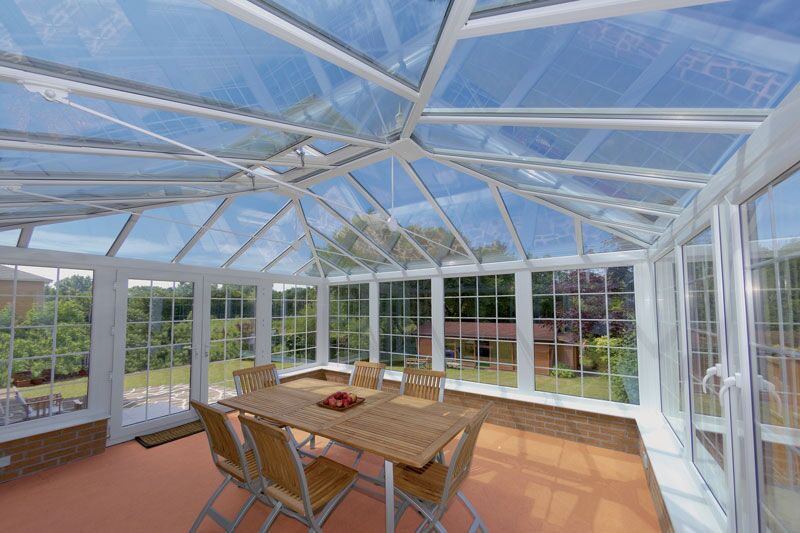 Inside a conservatory looking up at a glazed roof