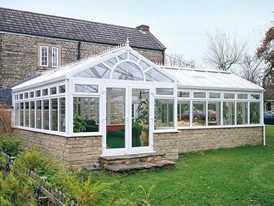 Glazed conservatory with a ridged roof on a stone base